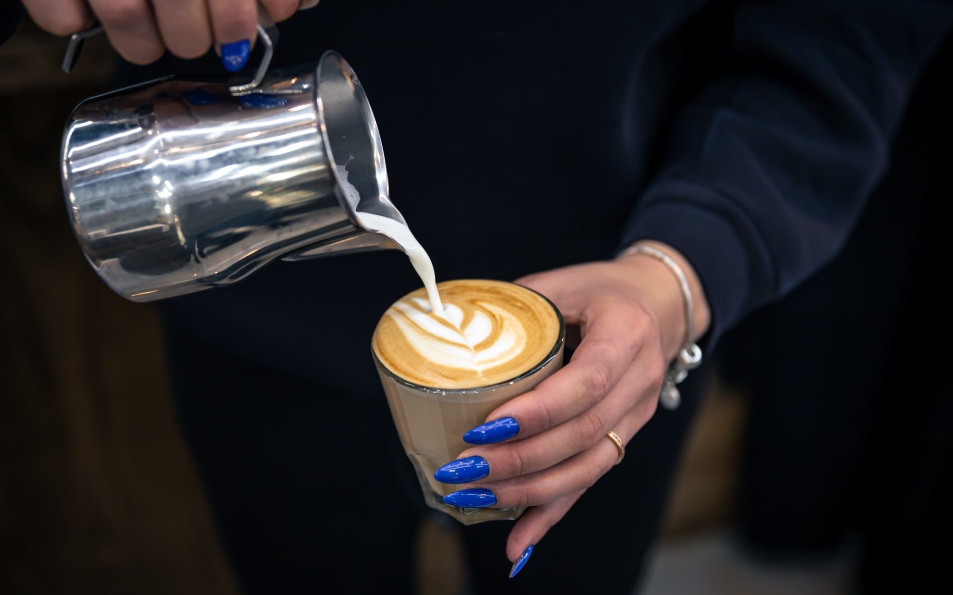 close-up-hand-of-a-woman-barista-pouring-froth-milk-in-espresso-coffee--e1651630473618.jpg